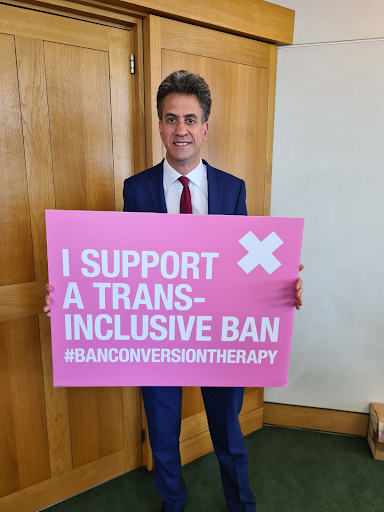 MP holding placard "I support a trans-inclusive ban"